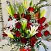 Red roses and white lilies in a basket with baby's breath