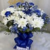 Blue and white flower arrangement with a butterfly topper and ribbon