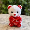 A soft and adorable plush teddy bear holding an &ldquo;I Love You&rdquo;