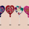 Four heart-shaped Mother's Day balloons on sticks in blue, red, white, and pink