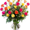 Mixed roses in pink, yellow, and orange arranged in a glass vase