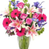 Mixed bouquet of pink roses, lilies, and gerbera daisies in a glass vase