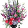 Tall mixed bouquet in a black vase with pink, purple, and blue flowers