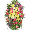 Standing floral spray with pink roses, yellow lilies, and purple accents