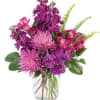 Purple and pink mixed bouquet in a clear glass vase