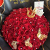 Heart-shaped bouquet of red roses with gold accents and a small crown