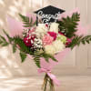 Pink and white bouquet with a graduation topper and ribbon