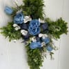 Cross-shaped floral arrangement with blue roses and white blossoms