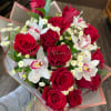 Vivid red roses paired with delicate white orchids create a romantic hand-tied