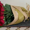 Bouquet of red roses wrapped in brown and gold paper