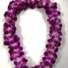 Purple orchid lei arranged in a loop on a white background