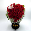 A dense cluster of red roses shaped into a rounded, full bouquet