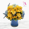 Yellow roses and orchids arranged in a blue vase