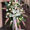Large white lilies take center stage in this sympathy standing spray, creating