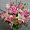 Bright pink roses mingle with pure white lilies in a garden-style birthday
