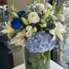 Blue and white floral arrangement in a clear glass vase