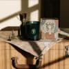Candle, trophy, and decorative box on a suitcase with a map cloth