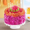 Round floral cake with candles and a pink rose topper