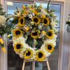 Large sunflower and white flower wreath on an easel