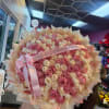 Large bouquet of pink and cream roses with a pink ribbon
