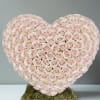 Heart-shaped arrangement of pale pink roses on a moss base