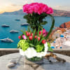 Tall bouquet of pink roses and red tulips in a glass vase