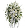 White floral standing spray with ribbon on an easel