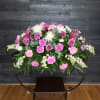 Large pink and white floral arrangement on a stand