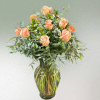A dozen gorgeous peach roses arranged in a vase.