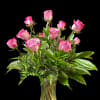 A dozen lavendar roses arranged in a vase.