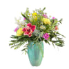 Colorful mix of spring flowers in a turquoise vase