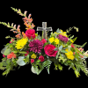 Crystal Cross surrounded with bright flowers including roses, snapdragons, cremons, etc.