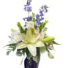 White lilies, blue delphinium, and chrysanthemums in a blue vase