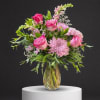 Pink roses and lavender chrysanthemums in a clear glass vase