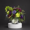 Purple and lime floral arrangement in a silver vase