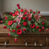 Red and pink floral arrangement with lilies, roses, and gerbera daisies