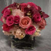 Pink and peach roses with orchids in a black square container