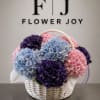 Basket of pink, blue, and purple hydrangeas with a handle