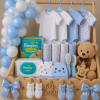 Baby gift basket with onesies, diapers, teddy bear, and blue balloons