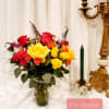 Bouquet of red, yellow, and orange roses in a glass vase