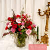 Mixed pink and red flower arrangement in a glass vase