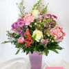 Mixed pink and white bouquet in a purple vase