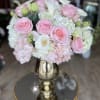 Pink roses and white calla lilies arranged in a gold vase