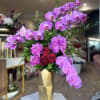 Pink orchids and red roses in a gold vase