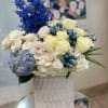 Blue and white floral arrangement in a white vase