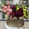 Pink roses and magenta flowers in a textured gold vase