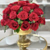 Red roses arranged in a gold pedestal vase