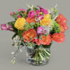 Colorful bouquet of roses and calla lilies in a glass vase