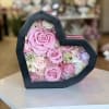 A heart-shaped black gift box reveals a keepsake of preserved roses and
