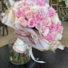Bouquet of pink and white roses wrapped in pastel paper with ribbon